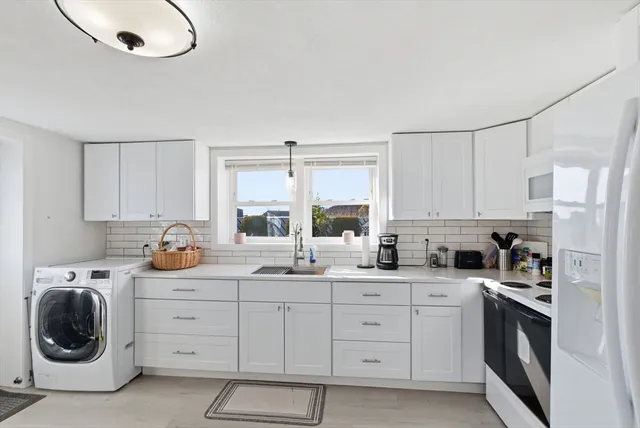 a kitchen with white cabinets and white appliances