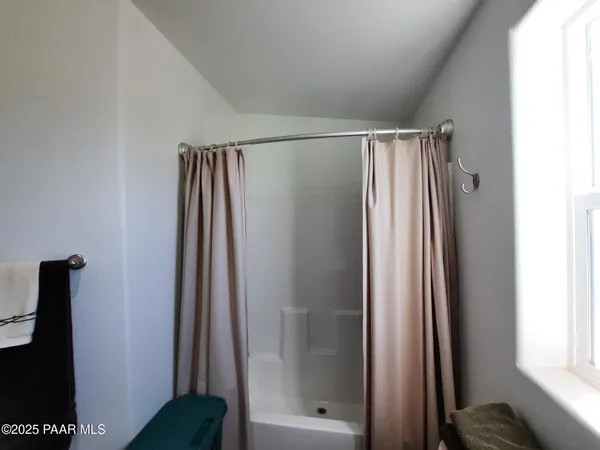 a view of a hallway with a livingroom and a bathroom with a mirror