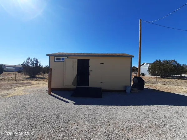 a couple of chairs sitting in patio next to a yard