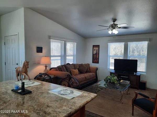 a kitchen with granite countertop a table chairs stove and refrigerator