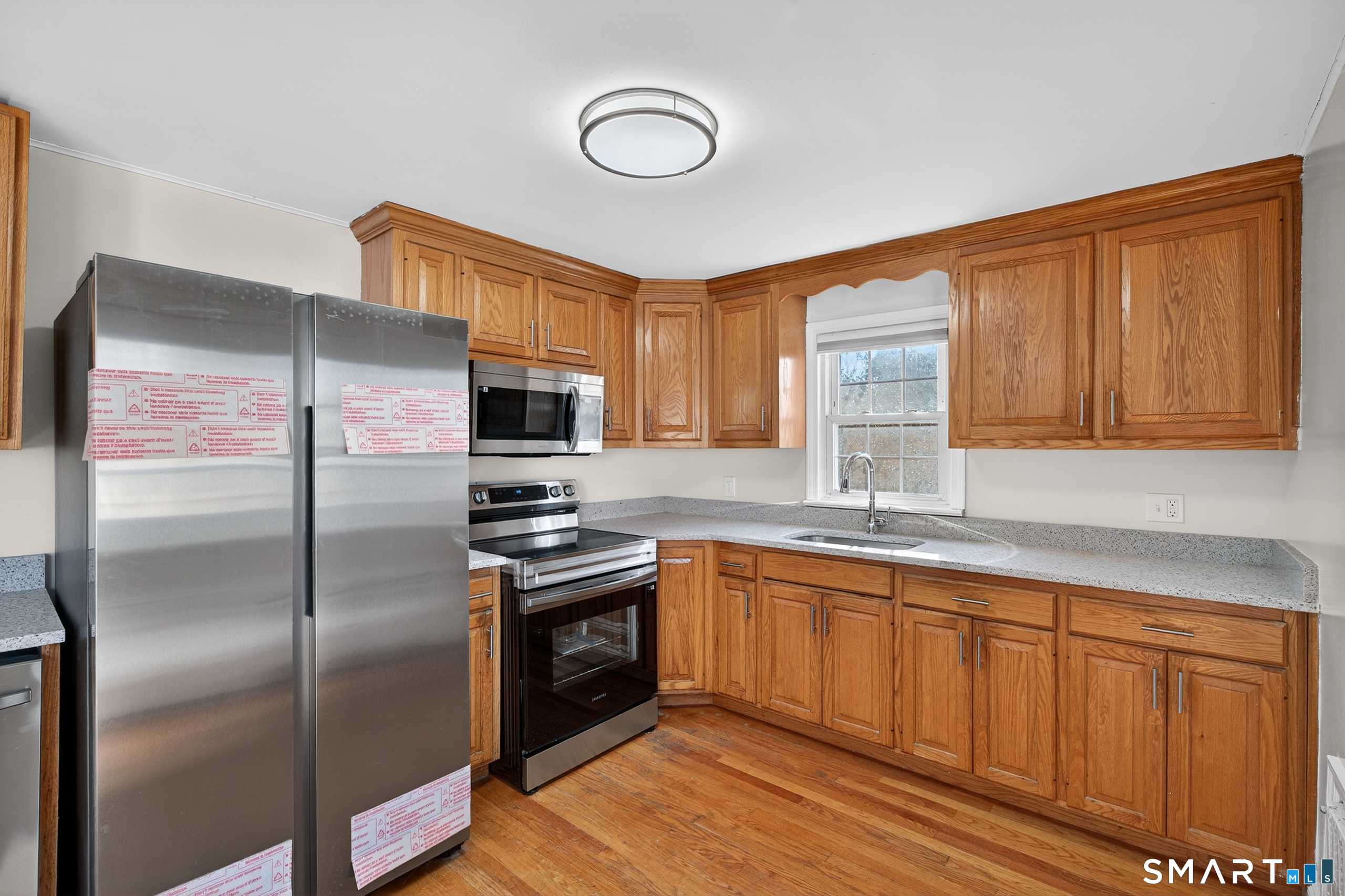195 Middletown Avenue Wethersfield, CT 06109 - Photo 11 of 35 a kitchen with stainless steel appliances granite countertop a refrigerator a sink dishwasher a stove with wooden cabinets and floor
