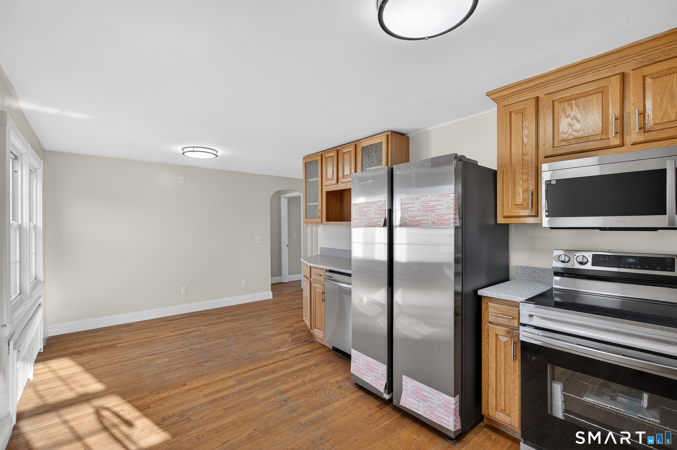 195 Middletown Avenue Wethersfield, CT 06109 - Photo 12 of 35 a kitchen with stainless steel appliances granite countertop a refrigerator a stove and a microwave with wooden floor