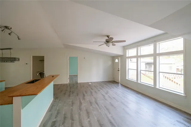 an empty room with windows and fan