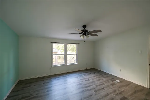 a view of a room with wooden floor and ceiling fan