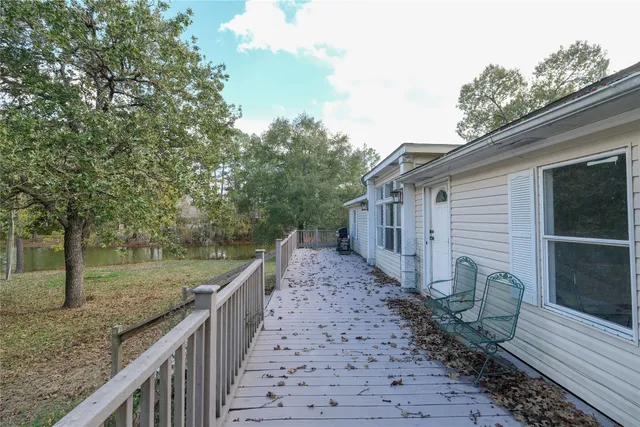 a view of a house with a small yard and large tree