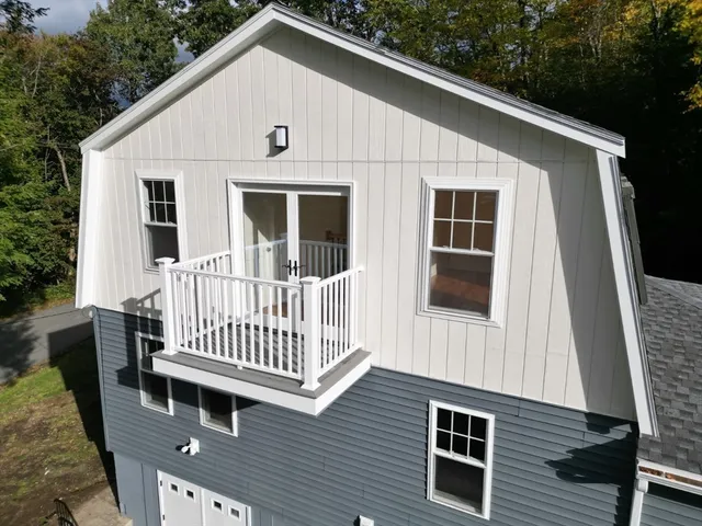 an aerial view of a house with a yard and tree s