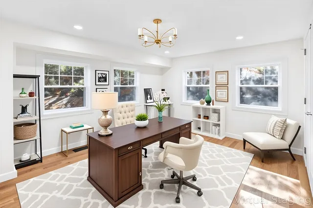 a view of a dining room with furniture a rug and wooden floor