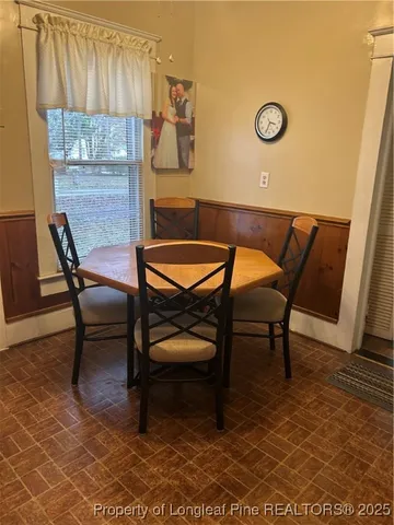 a dining room with a wooden table and chairs