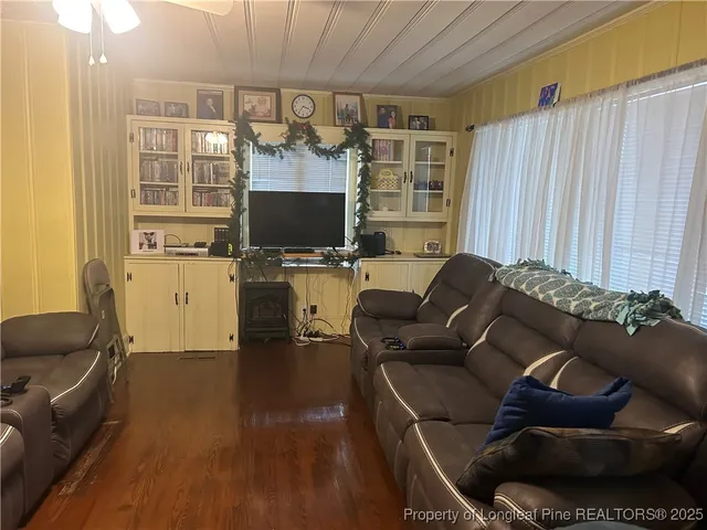 a living room with furniture a flat screen tv and a window