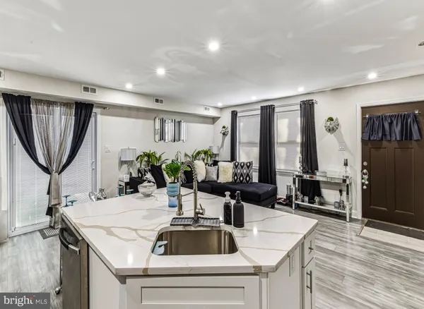 a kitchen with a sink a counter and chairs