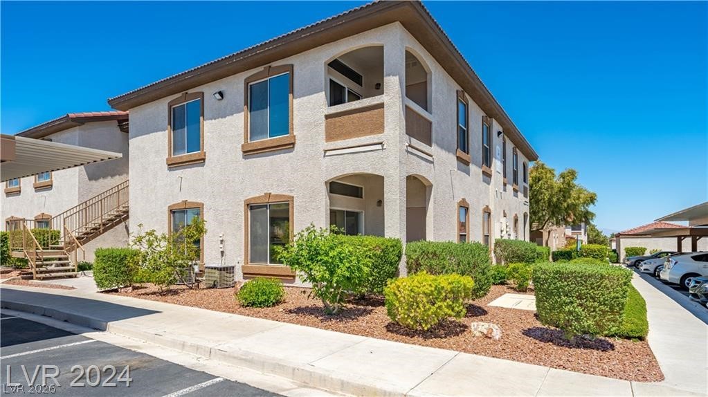 2305 West Horizon Ridge Parkway, Unit 1411 Henderson, NV 89052 - Photo 1 of 17 This residential building offers convenient exterior stairs and an adjacent parking area under a clear sky.