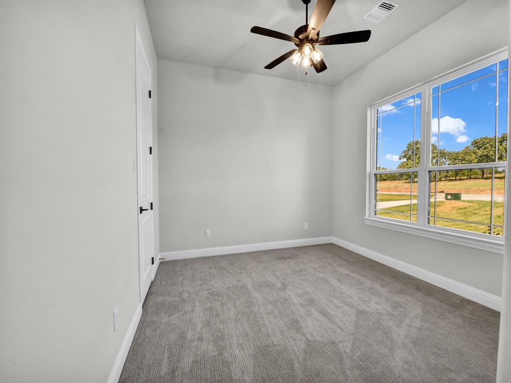 3009 Codigo Drive Weatherford, TX 76088 - Photo 32 of 40 an empty room with windows and chandelier fan