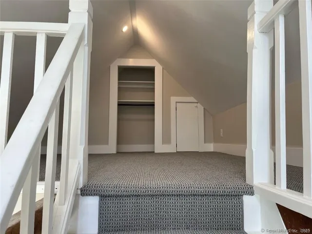 a view of hallway with stairs and a couch