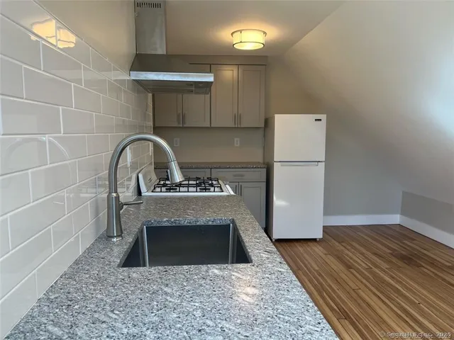 a kitchen with a refrigerator sink and cabinets