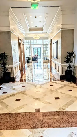 a living room with furniture large windows and wooden floor