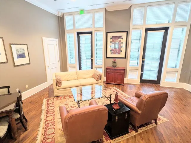 a bedroom with a bed and large windows