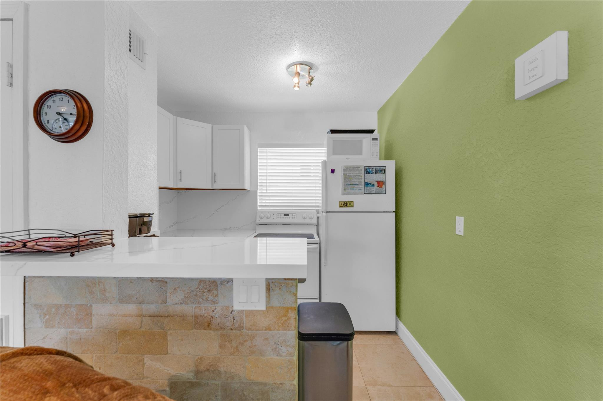 3225 Northeast 16th Street, Unit 10 Pompano Beach, FL 33062 - Photo 11 of 22 a kitchen with a refrigerator and a stove top oven