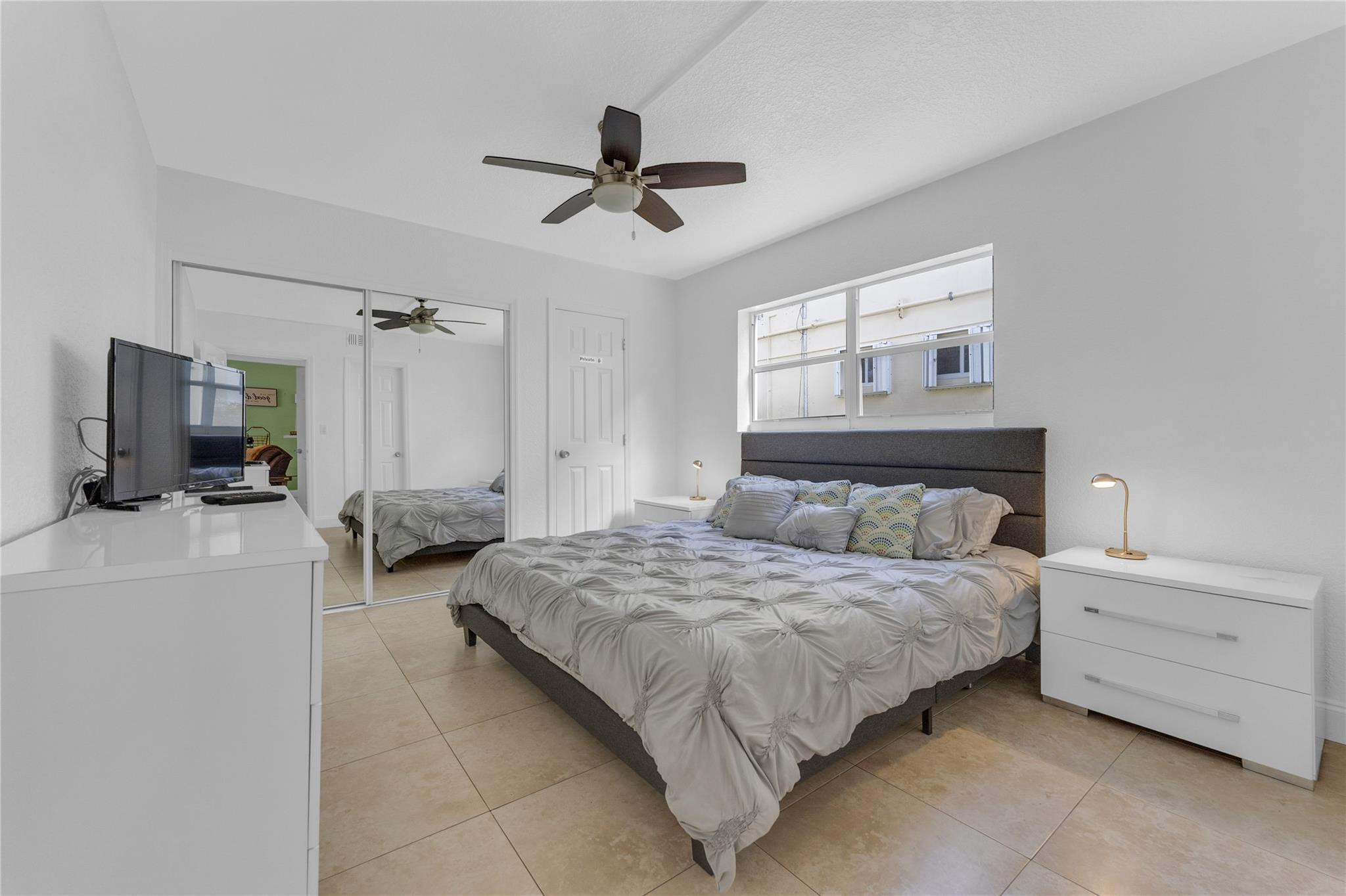 3225 Northeast 16th Street, Unit 10 Pompano Beach, FL 33062 - Photo 15 of 22 a bedroom with a bed a couch and a flat screen tv