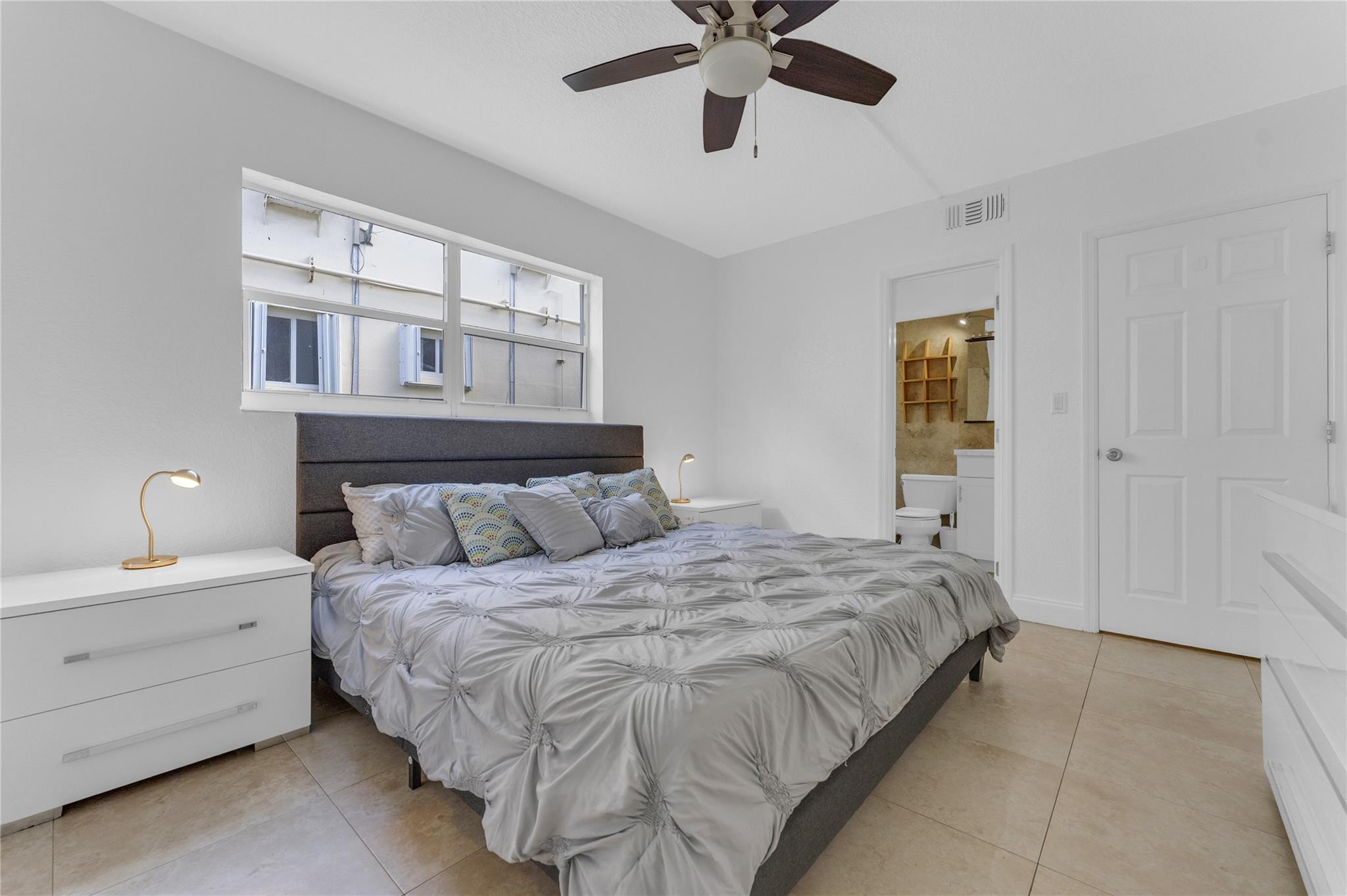 3225 Northeast 16th Street, Unit 10 Pompano Beach, FL 33062 - Photo 16 of 22 a bedroom with a bed and a chandelier