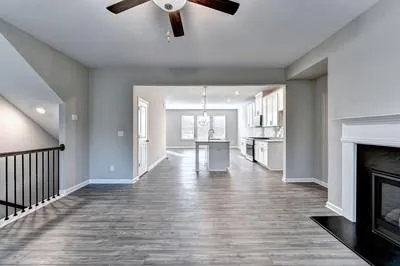 a view of an empty room with wooden floor fireplace and a window