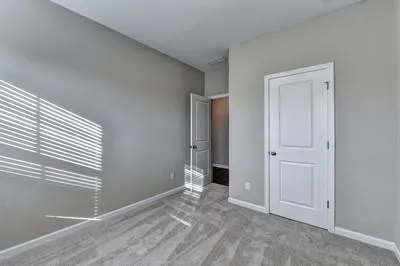 an empty room with windows and closet