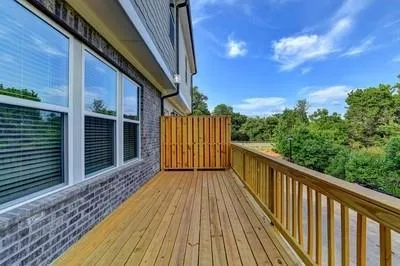a view of a balcony with wooden floor and fence