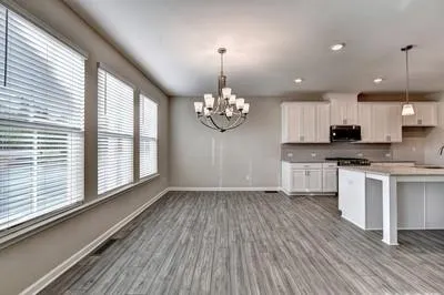 a view of a kitchen with granite countertop wooden floor stainless steel appliances and a large window