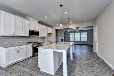 a kitchen with stainless steel appliances granite countertop a sink stove and wooden floor