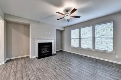 a view of an empty room with a window and fireplace