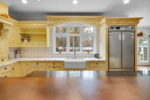 a view of large kitchen with granite countertop a large window and a sink