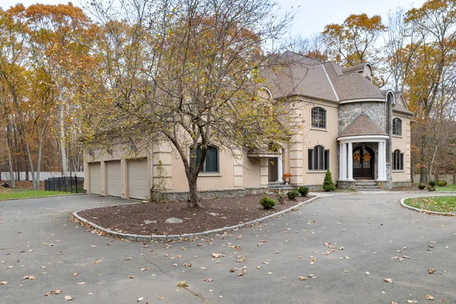 a view of a white house with a yard and large tree