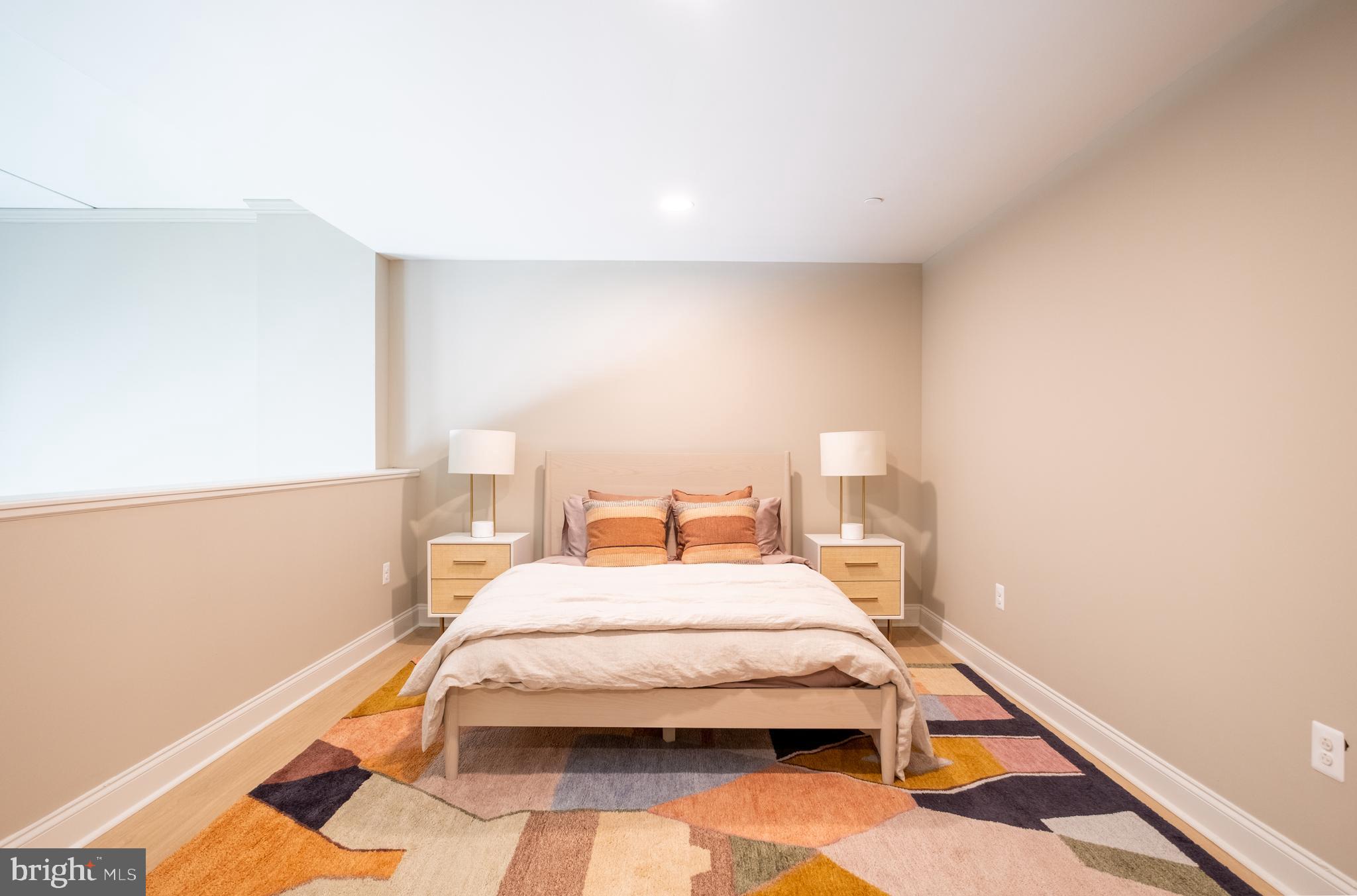 2301-61 John F Kennedy Boulevard, Unit 213 Philadelphia, PA 19103 - Photo 10 of 36 a bedroom with a bed and a lamp on the dresser