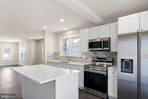 a kitchen with stainless steel appliances a stove microwave and sink