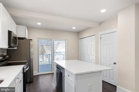a kitchen with a refrigerator a sink dishwasher a stove and a refrigerator with wooden floor