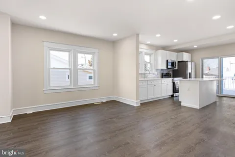 a view of a kitchen with furniture and wooden floor
