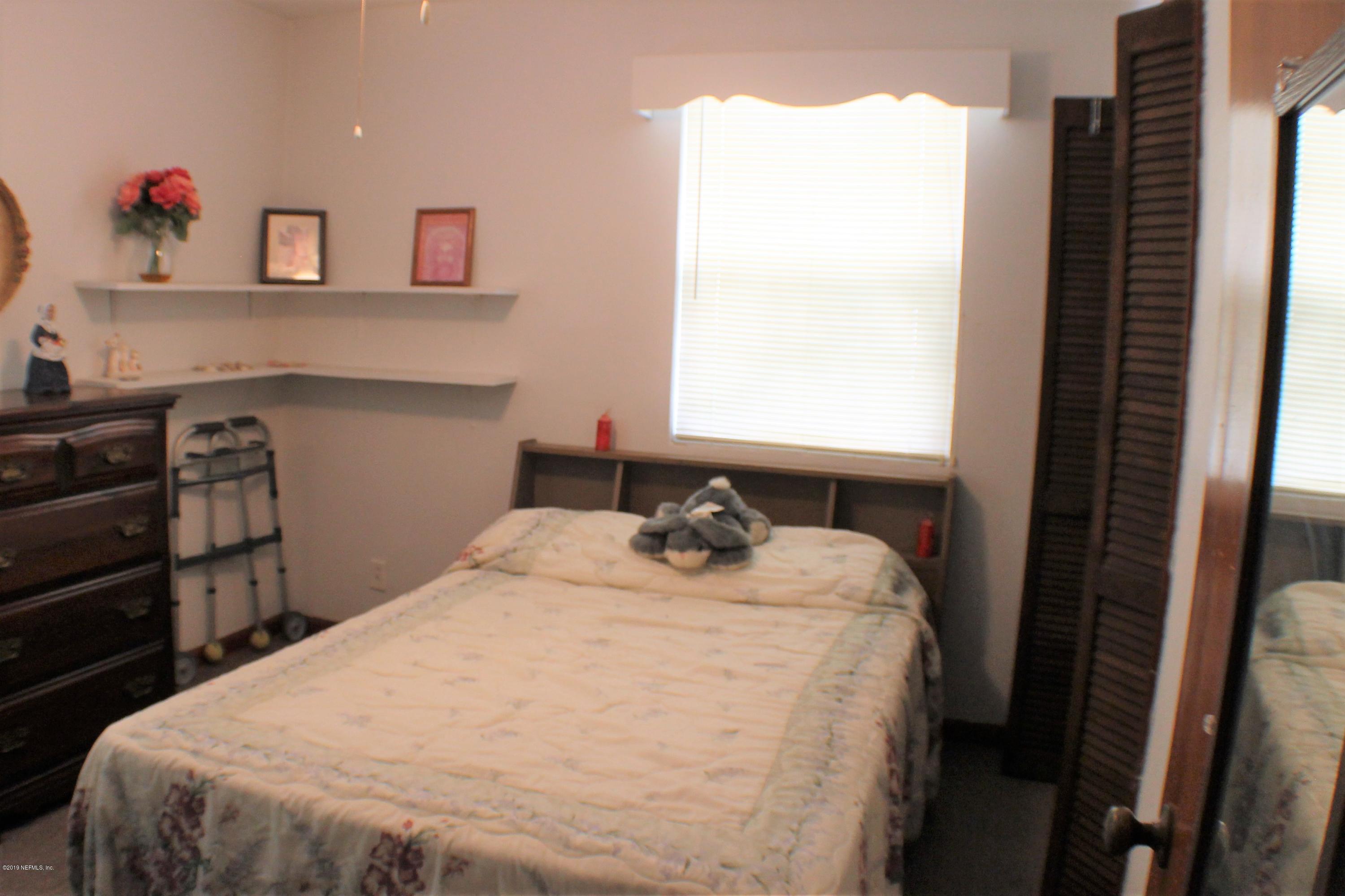 2346 Gayland Road Jacksonville, FL 32218 - Photo 7 of 14 a bed sitting in a bedroom next to a window