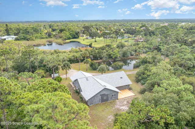 an aerial view of a house with a yard and lake view