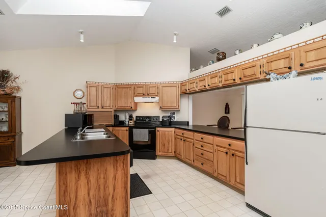a kitchen with stainless steel appliances a stove top oven a sink a counter top space and cabinets