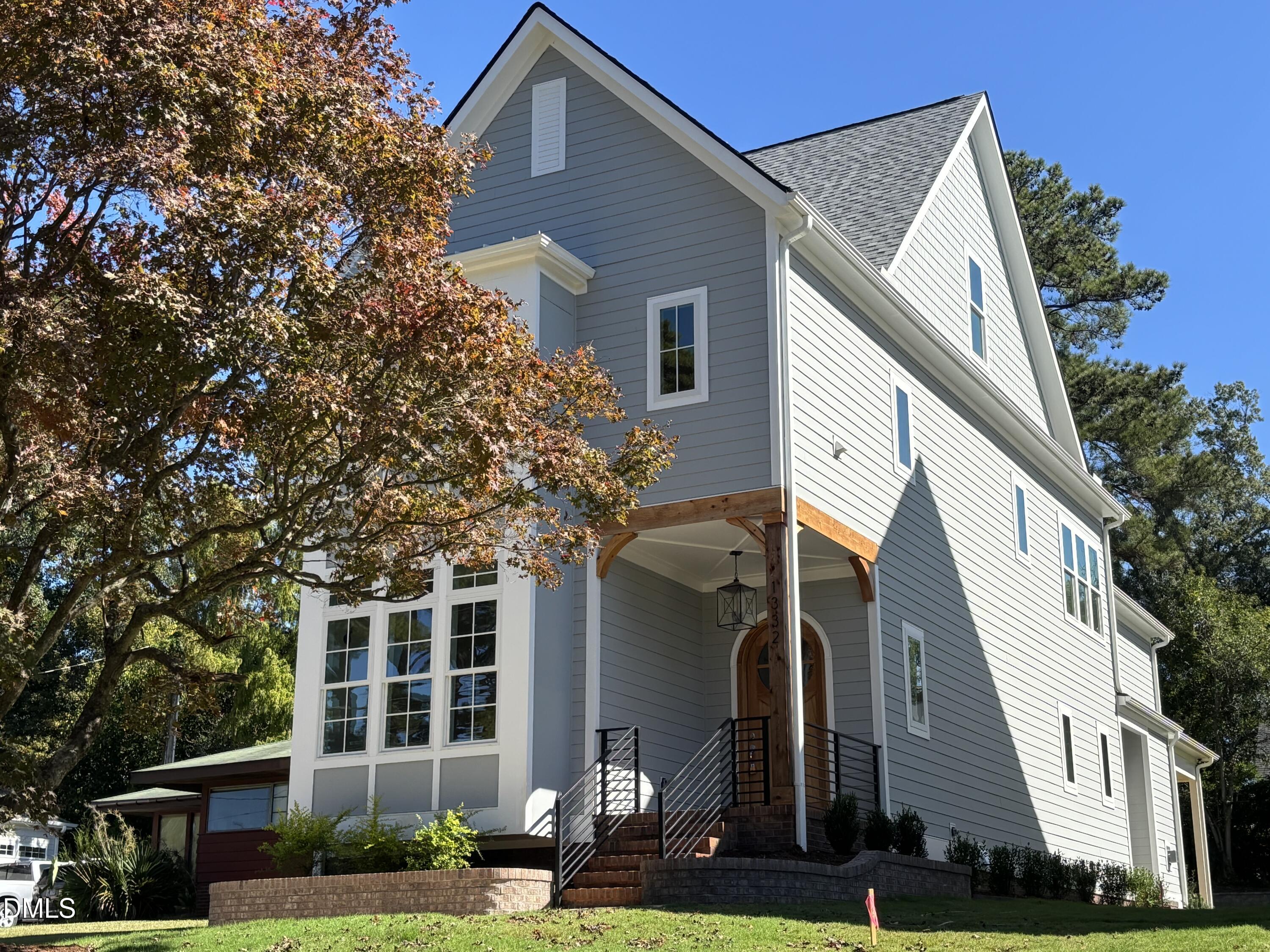 1332 Duplin Road Raleigh, NC 27607 - Photo 2 of 50 a view of a white house with large windows and a yard