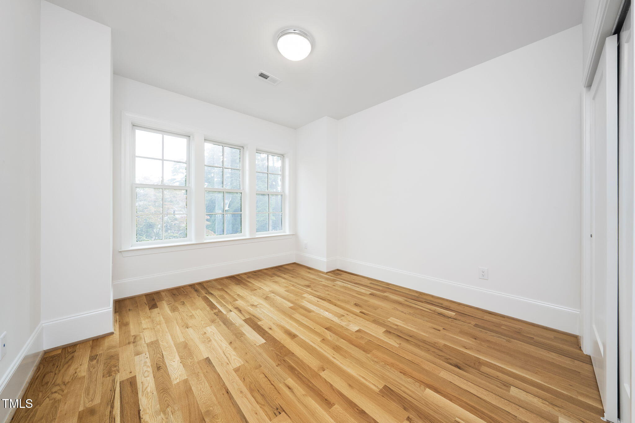 1332 Duplin Road Raleigh, NC 27607 - Photo 31 of 50 an empty room with wooden floor and windows