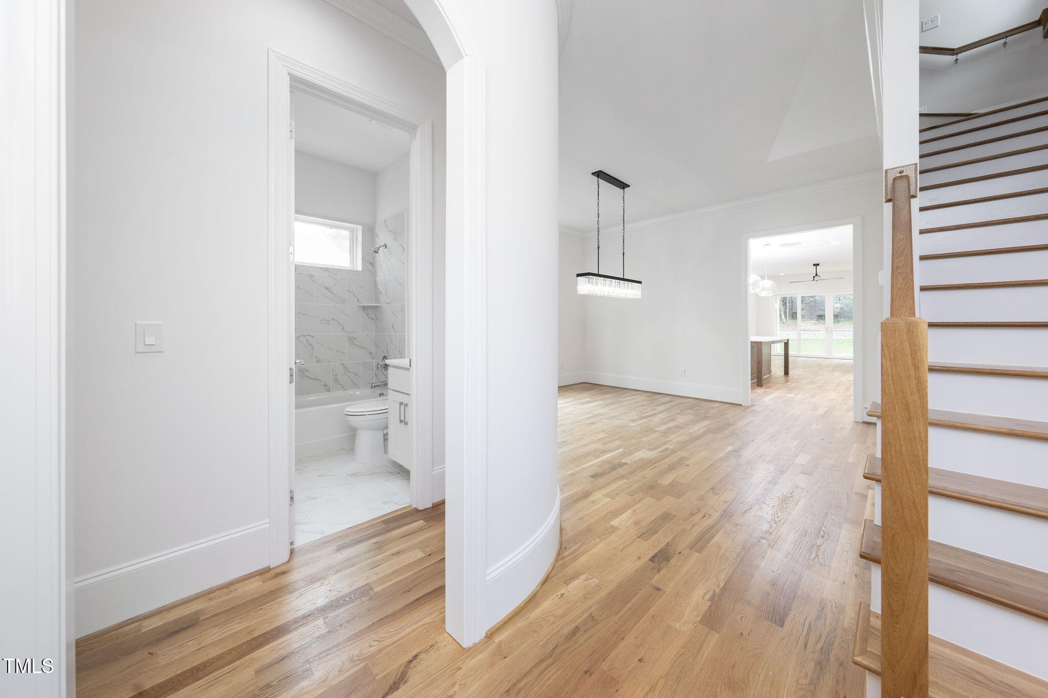 1332 Duplin Road Raleigh, NC 27607 - Photo 7 of 50 a view of a hallway with wooden floor a glass door and a bathroom