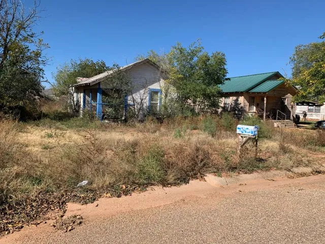 a backyard of a house with barbeque oven table and chairs under an umbrella