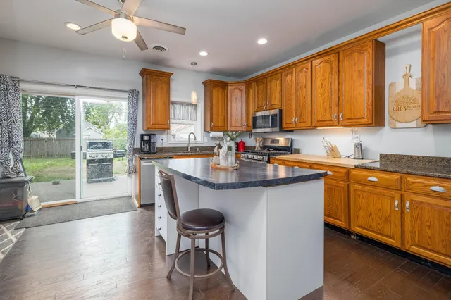 a kitchen with stainless steel appliances granite countertop sink stove and wooden cabinets