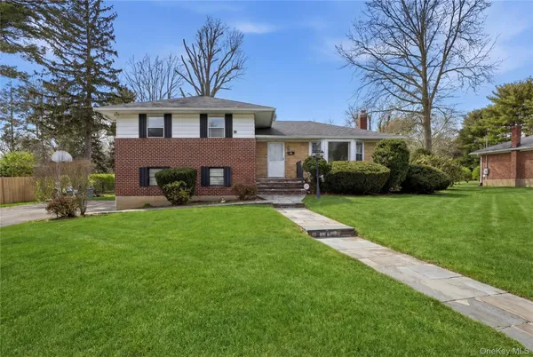 a front view of a house with a yard and trees