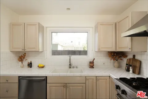 a kitchen with white cabinets and a window