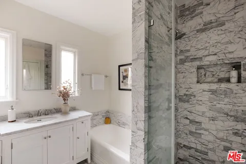 a bathroom with a granite countertop sink and a mirror