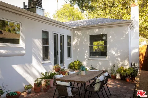 a backyard of a house with table and chairs