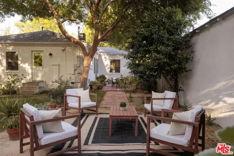 a view of backyard of house with outdoor seating