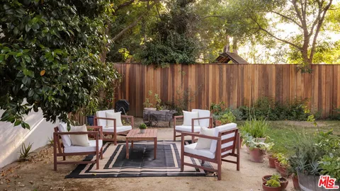 a view of a patio with chair table and chairs and potted plants
