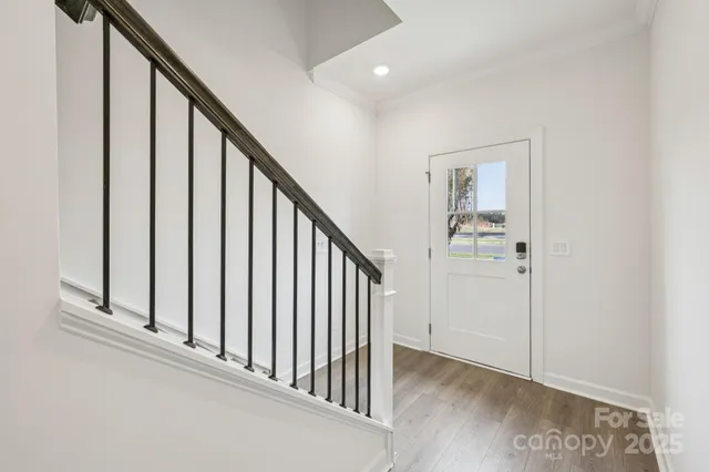 a view of a hallway with wooden floor and entryway